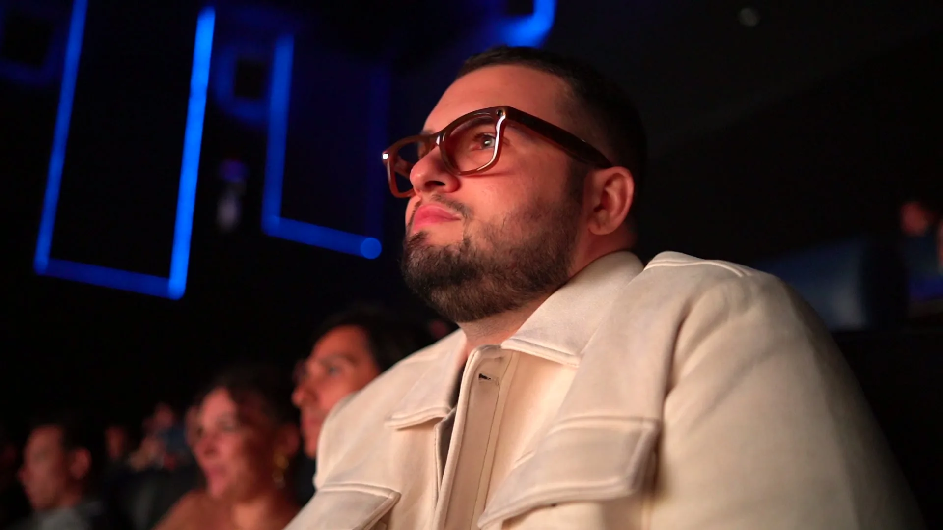 Marco Guimarães na plateia do RAIFF 2025, iluminado pela tela do cinema